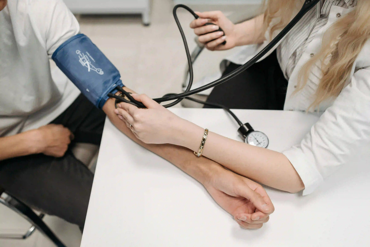 Frau misst Blutdruck bei Patient