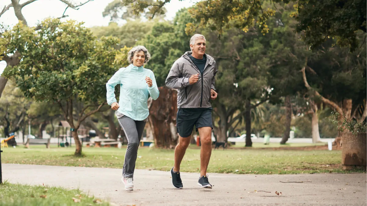 Mann und Frau mittleren Alters joggen im Park